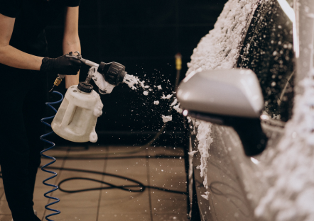 Specialist brengt actief schuim aan op auto met foam lance