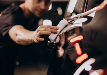 Detailingspecialist brengt met een doek keramische coating aan op glanzende lak